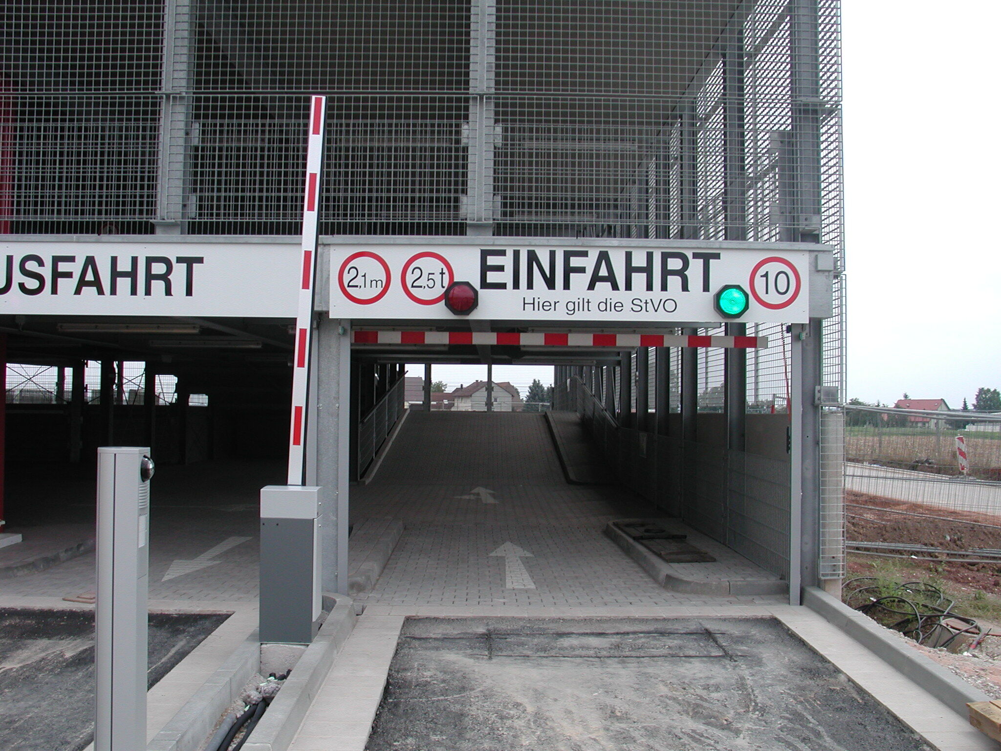 Einfahrt in ein modernes Parkhaus mit Schranke und Zufahrtskontrolle Einfahrt in ein Parkhaus mit Schranke, grüner Ampel, Höhen- und Gewichtsbeschränkung sowie Geschwindigkeitsbegrenzung.